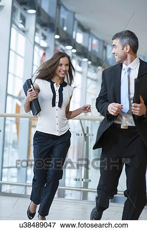 Stock Photo - Happy businessman and businesswoman running. Fotosearch