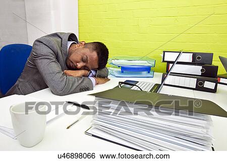 Indian businessman asleep at his desk View Large Photo Image Stock Photograph - Indian businessman asleep at his desk. Fotosearch