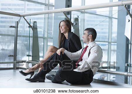 Male and female coworkers sitting and joking together View Large Photo Image Stock Photo - Male and female coworkers sitting and joking together. Fotosearch