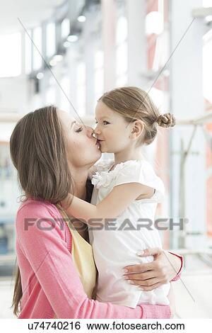 Stock Photograph - Mother and daughter hug and kiss. Fotosearch