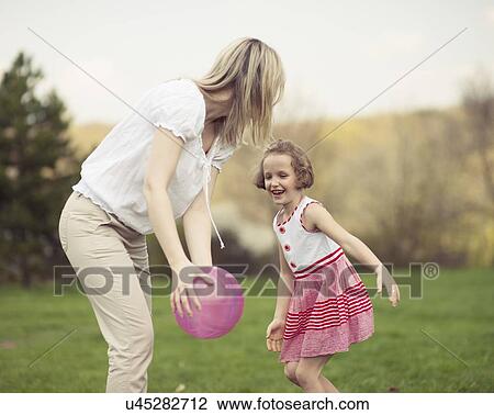 Mother and daughter playing with ball in the park View Large Photo Image Stock Image - Mother and daughter playing with ball in the park. Fotosearch