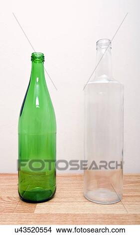Picture - one green glass bottle and one clear glass bottle . Fotosearch