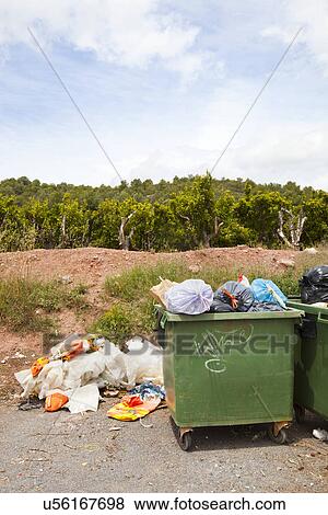 Stock Photo - Overflowing bins next to Orange Orchard, Valencia region, Spain. Fotosearch