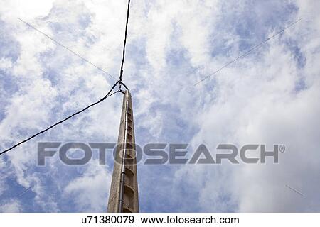 Stock Photo - Power line against blue sky and sun. Fotosearch