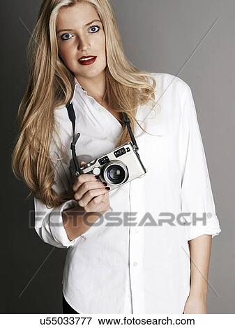 Pretty blonde girl holding camera View Large Photo Image Stock Photo - Pretty blonde girl holding camera. Fotosearch