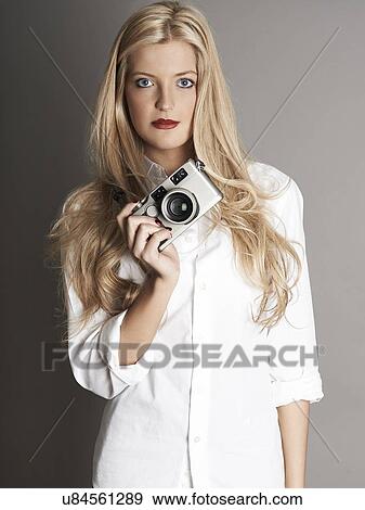 Pretty blonde girl holding camera View Large Photo Image Stock Photo - Pretty blonde girl holding camera. Fotosearch
