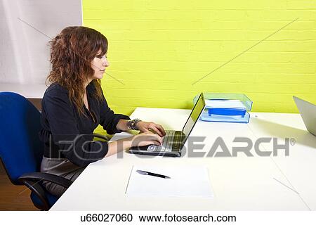 Side view of woman working at her computer View Large Photo Image Stock Image - Side view of woman working at her computer. Fotosearch
