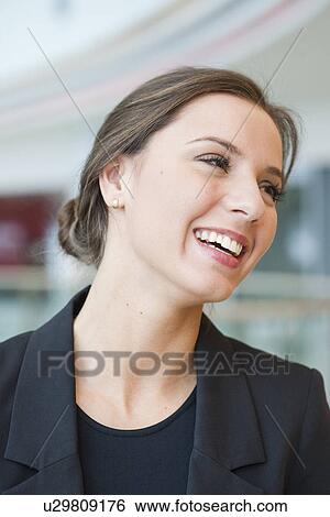 Stock Photograph - Smiling businesswoman looking off camera. Fotosearch