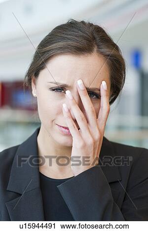 Stock Image - Stressed businesswoman looking at camera. Fotosearch