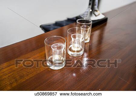 Three empty shot glasses on a bar View Large Photo Image Stock Photo - Three empty shot glasses on a bar. Fotosearch