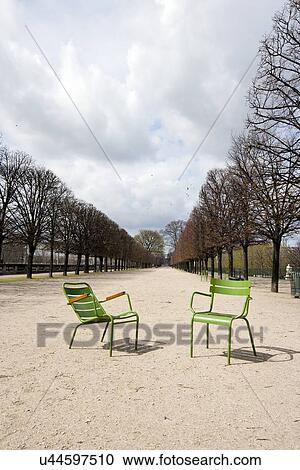 Stock Image - Two Green Chairs on a path In Paris, France. Fotosearch