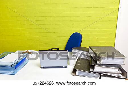 Stock Photograph - Vacant desk with laptop, folders and empty chair. Fotosearch