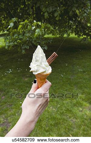 Womans hand holding soft serve ice cream View Large Photo Image Stock Photo - Womans hand holding soft serve ice cream. Fotosearch