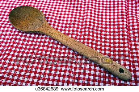 Stock Photo - Wooden spoon close up on a red and white tablecloth. Fotosearch