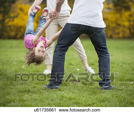 Young couple swinging daughter between them View Large Photo Image Stock Image - Young couple swinging daughter between them . Fotosearch