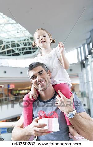 Stock Image - Young daughter sits on fathers shoulders. Fotosearch