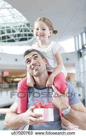 Young daughter sits on fathers shoulders View Large Photo Image Stock Image - Young daughter sits on fathers shoulders. Fotosearch