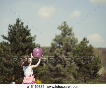 Young girl catching purple ball in park View Large Photo Image Stock Photograph - Young girl catching purple ball in park. Fotosearch