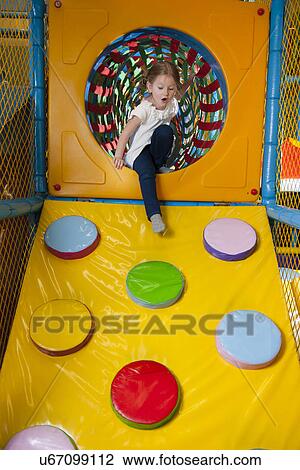 Young girl climbing down ramp in soft play centre View Large Photo Image Stock Image - Young girl climbing down ramp in soft play centre. Fotosearch