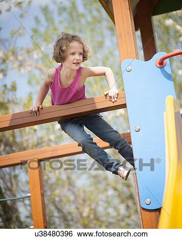 Young girl climbing on childrens playground View Large Photo Image Stock Photograph - Young girl climbing on childrens playground. Fotosearch