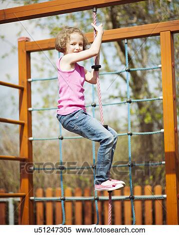 Young girl climbing rope in playground View Large Photo Image Stock Photography - Young girl climbing rope in playground. Fotosearch