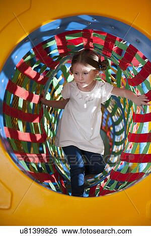Young girl climbs through netted tunnel in soft play centre View Large Photo Image Stock Photograph - Young girl climbs through netted tunnel in soft play centre. Fotosearch