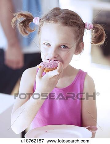 Young girl eating cake in kitchen View Large Photo Image Stock Photo - Young girl eating cake in kitchen. Fotosearch