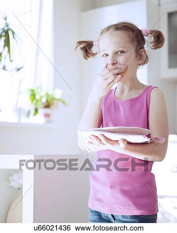 Young girl eating cake in kitchen View Large Photo Image Stock Photograph - Young girl eating cake in kitchen. Fotosearch