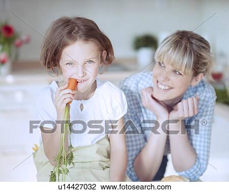 Stock Image - Young girl eating carrot. Fotosearch