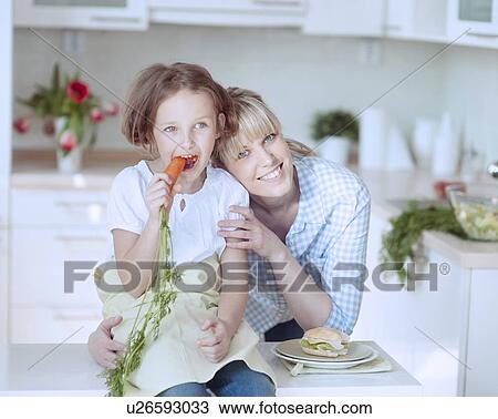Stock Image - Young girl eating carrot. Fotosearch