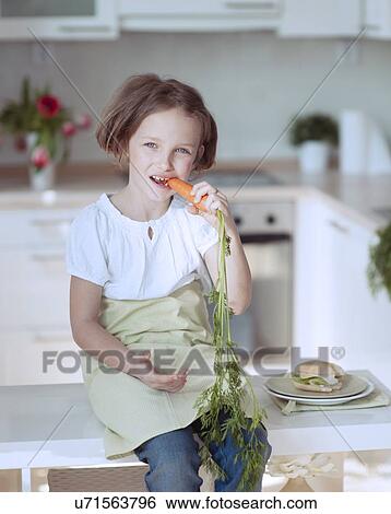 Stock Photograph - Young girl eating carrot. Fotosearch