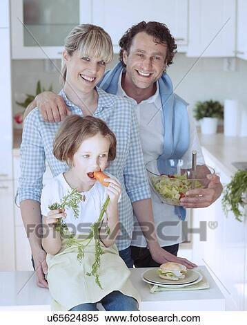 Young girl eating carrot with parents View Large Photo Image Stock Photography - Young girl eating carrot with parents. Fotosearch