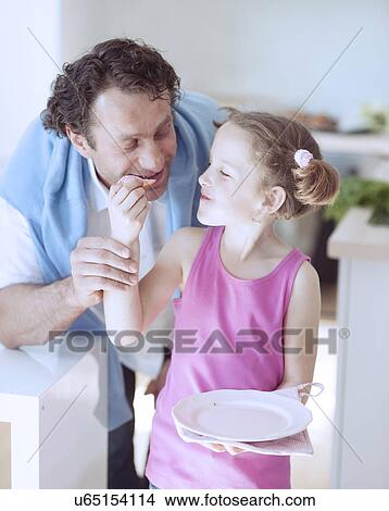 Young girl feeding her father View Large Photo Image Picture - Young girl feeding her father. Fotosearch