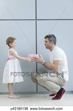 Stock Photo - Young girl handing present to her father. Fotosearch