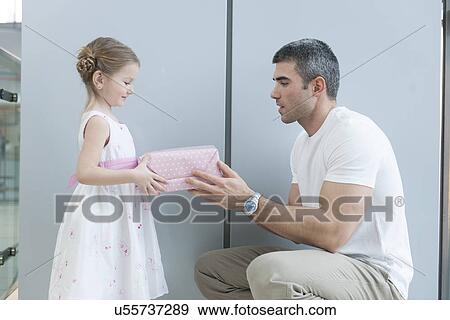 Stock Photo - Young girl handing present to her father. Fotosearch