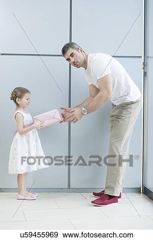 Young girl handing present to her father View Large Photo Image Stock Photo - Young girl handing present to her father. Fotosearch