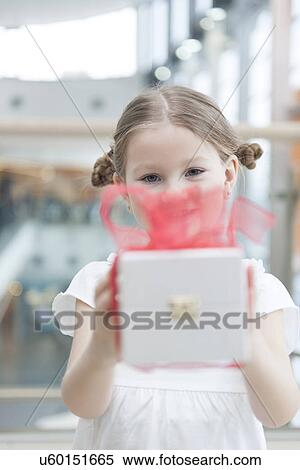 Young girl handing present towards camera View Large Photo Image Stock Photography - Young girl handing present towards camera. Fotosearch