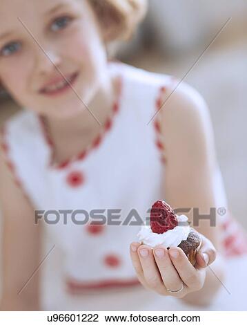 Young girl holding cup cake View Large Photo Image Stock Image - Young girl holding cup cake. Fotosearch
