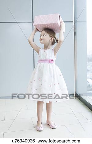 Young girl holding gift wrapped box on her head View Large Photo Image Stock Photograph - Young girl holding gift wrapped box on her head. Fotosearch