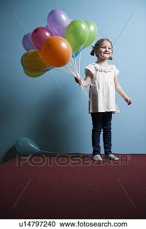 Young girl holds bunch of colorful balloons View Large Photo Image Stock Image - Young girl holds bunch of colorful balloons. Fotosearch