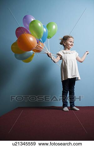Young girl holds bunch of colorful balloons View Large Photo Image Stock Photo - Young girl holds bunch of colorful balloons. Fotosearch