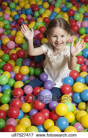 Young girl in ball pit throwing colored balls View Large Photo Image Stock Photo - Young girl in ball pit throwing colored balls. Fotosearch