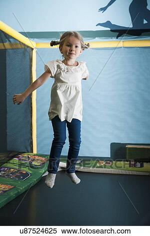 Young girl in mid air on trampoline View Large Photo Image Stock Photography - Young girl in mid air on trampoline. Fotosearch