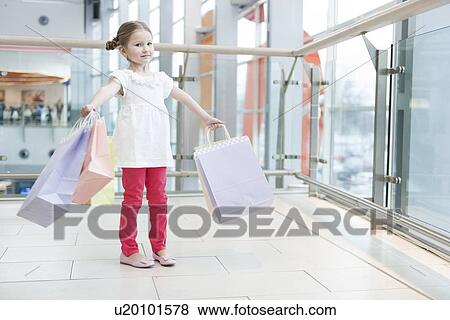 Young girl laden with paper shopping bags View Large Photo Image Stock Photo - Young girl laden with paper shopping bags. Fotosearch