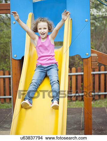 Young girl on slide in playground View Large Photo Image Picture - Young girl on slide in playground. Fotosearch