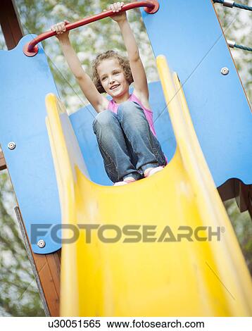 Young girl on slide in playground View Large Photo Image Stock Photography - Young girl on slide in playground. Fotosearch