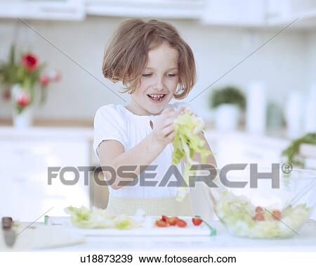 Young girl placing lettuce in salad bowl View Large Photo Image Stock Photo - Young girl placing lettuce in salad bowl. Fotosearch