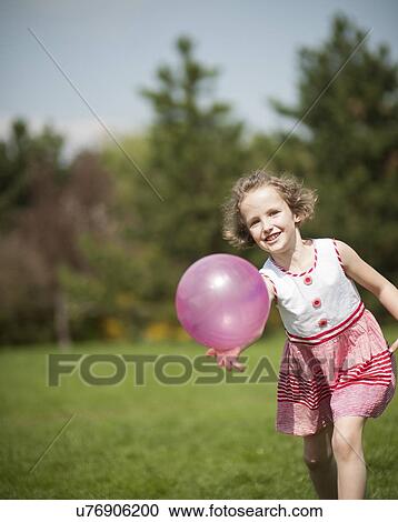 Young girl playing with purple ball in the park View Large Photo Image Stock Image - Young girl playing with purple ball in the park. Fotosearch