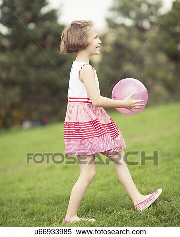 Young girl playing with purple ball in the park View Large Photo Image Stock Photography - Young girl playing with purple ball in the park. Fotosearch