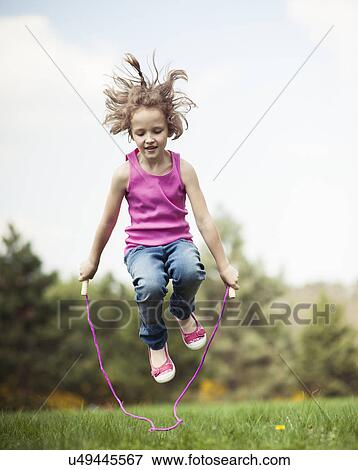 Young girl skipping in park View Large Photo Image Stock Photo - Young girl skipping in park. Fotosearch